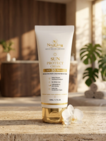 A squeeze tube of NovaGlow Sun Protect Cream SPF 50 PA++++ with a gold cap, standing on a stone surface with a blurred spa-like background and a white orchid flower at its base.